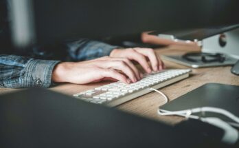 Un ragazzo che digita su una tastiera bianca